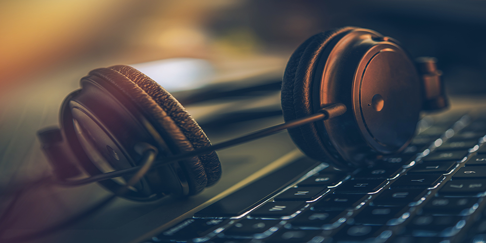 Online Digital Music Headphones and the Laptop Computer. Professional Headphones on the Computer Keyboard.
